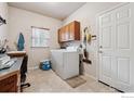 Functional laundry room with storage cabinets, washer, dryer, and natural light at 3413 Boxelder Dr, Longmont, CO 80503