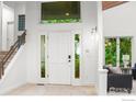 Bright foyer with travertine tile, a staircase, a large window, and a stylish front door at 3421 4Th St, Boulder, CO 80304