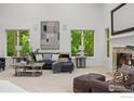 Bright living room features a vaulted ceiling, fireplace, large windows with lush, green outdoor views at 3421 4Th St, Boulder, CO 80304
