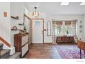 Inviting entryway with hardwood floors, a decorative rug, stylish decor, and natural light from a skylight at 3593 S Gibralter Cir, Aurora, CO 80013