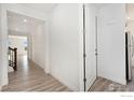 Inviting hallway featuring stylish wood floors and pristine white walls, creating a bright and airy atmosphere at 5226 Inland Ave, Firestone, CO 80504