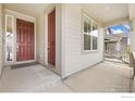 Inviting front porch showcasing a wood door with sidelight and neutral siding at 5226 Inland Ave, Firestone, CO 80504
