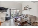 Well-lit living room featuring a gray couch, hardwood floors, and an entertainment center at 5415 W 16Th Ave, Lakewood, CO 80214