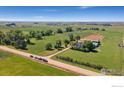 Picturesque farmhouse estate with long driveway, and expansive land, surrounded by lush greenery at 5416 County Road 36, Platteville, CO 80651