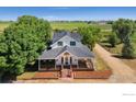 Charming farmhouse with a spacious porch, perfect for enjoying the serene countryside setting at 5416 County Road 36, Platteville, CO 80651