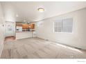 Bright living room featuring a large window and views into the kitchen at 67 Quail Rd, Longmont, CO 80501