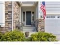 Inviting front porch with stone accents and a view of the two car garage at 688 Ten Gallon Dr, Berthoud, CO 80513