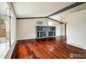 Spacious living area with hardwood floors, large windows, and a decorative fireplace at 7210 Otis Ct, Arvada, CO 80003