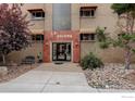 A lovely front facade of a charming apartment building entrance with rocks and a small bench at 733 E 2Nd Ave # 307, Denver, CO 80203
