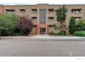 Charming apartment building with tan brick, window awnings, and professional landscaping at 733 E 2Nd Ave # 307, Denver, CO 80203