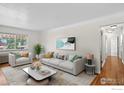 Spacious living room with a large window and comfortable seating arrangement at 733 E 2Nd Ave # 307, Denver, CO 80203
