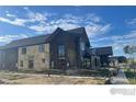 A modern apartment complex under construction, showcasing its architectural design and proximity to a sidewalk at 917 Latigo Loop, Lafayette, CO 80026