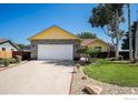 Well-manicured lawn leading up to a charming home with a spacious two-car garage at 1030 S Fulton Ave, Fort Lupton, CO 80621