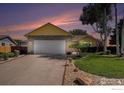 Well-manicured lawn leading up to a charming home with a spacious two-car garage at 1030 S Fulton Ave, Fort Lupton, CO 80621