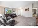 Cozy living room with vaulted ceilings and large windows at 1030 S Fulton Ave, Fort Lupton, CO 80621