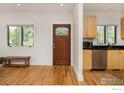 Bright living room with hardwood floors, a decorative door, and an adjacent kitchenette at 1260 Claremont Dr, Boulder, CO 80305