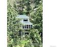 Charming two-story home with green siding nestled among lush pine trees at 160 Valley Ln, Boulder, CO 80302