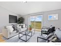 Bright living room with a sliding glass door, modern furniture, and neutral decor for a cozy space at 18674 County Road 3, Berthoud, CO 80513