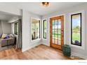 Bright entryway featuring a wood door, stylish flooring, and natural light at 2017 Vaquero St, Longmont, CO 80504