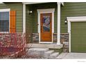 Close-up of a home's entrance with a stained wood door, stone accents, and decorative wreath at 2310 Angus St, Mead, CO 80542