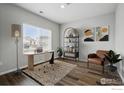 Bright home office with hardwood floors, large window, desk, chair, and stylish decorations at 2310 Angus St, Mead, CO 80542