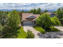 Charming home with a well-maintained lawn, mature trees, and mountain views at 2384 Ponderosa Pl, Erie, CO 80516