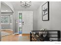 Bright foyer with wood floors, modern light fixture, and decorative art at 2384 Ponderosa Pl, Erie, CO 80516