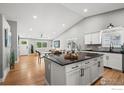 Open-concept kitchen with a center island, modern appliances, and hardwood floors at 2384 Ponderosa Pl, Erie, CO 80516