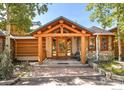 Welcoming entrance with log beams, custom front door and stacked stone accents at 24043 Eagle Cliff Trl, Conifer, CO 80433