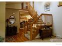 Inviting foyer with hardwood floors and a wooden staircase, creating a warm and welcoming entrance to the home at 2465 Mapleton Cir, Longmont, CO 80503
