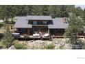 Rear exterior of a gray roof home with a deck featuring patio furniture, perfect for enjoying the outdoor views at 311 Sky Trail Rd, Boulder, CO 80302