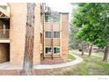 Brick apartment building showing balconies, mature trees, and a well-maintained landscape at 3393 Madison Ave # 128, Boulder, CO 80303