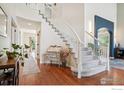 Bright foyer featuring a curved staircase with carpeted steps, hardwood flooring, and stylish decor at 345 Onyx Way, Superior, CO 80027