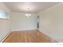 Inviting dining room featuring hardwood floors, a classic chandelier, and views of the adjacent rooms at 353 S Niagara St, Denver, CO 80224