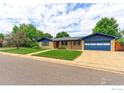 Well-maintained single-story home featuring a lush green lawn and a driveway leading to an attached garage at 353 S Niagara St, Denver, CO 80224