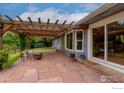 Charming outdoor patio with stone flooring, wooden pergola, and comfortable seating, perfect for entertaining at 419 Centennial Dr, Louisville, CO 80027
