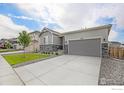 Attractive home exterior featuring a well-kept lawn, modern siding, and a concrete driveway at 4596 Hatcher Dr, Brighton, CO 80601