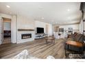 Open-concept living room featuring a cozy fireplace, hardwood floors, and modern decor at 4596 Hatcher Dr, Brighton, CO 80601