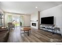 Bright living room with fireplace, hardwood floors, and sliding glass doors to the backyard at 4596 Hatcher Dr, Brighton, CO 80601