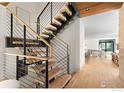 Modern staircase with light wood steps and black railing, leading to open-concept living space at 550 Iris Ave, Boulder, CO 80304