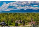 An aerial view captures a beautiful home with the rocky mountains in the horizon at 5986 Heather Way, Longmont, CO 80503