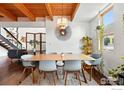 Open dining area with wood ceilings, modern light fixture, and unique wall decor at 801 Confidence Dr # 15, Longmont, CO 80504