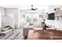 Bright living room with neutral tones, plank flooring, and modern shelving at 897 Winding Brook Dr, Berthoud, CO 80513