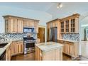 Well-equipped kitchen with light wood cabinetry, granite counters, stainless appliances, and a kitchen island at 10947 W 100Th Dr, Westminster, CO 80021