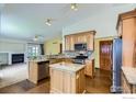 Bright kitchen featuring wood cabinets, granite countertops, stainless steel appliances, and an island at 10947 W 100Th Dr, Westminster, CO 80021