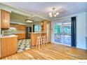 Inviting kitchen with hardwood floors, bar seating, and sliding glass doors leading to an outdoor deck area at 1209 S Terry St, Longmont, CO 80501