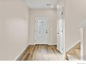 Clean entryway with wood floors, a frosted glass door, and white trim work throughout at 14827 Longhorn Dr, Mead, CO 80542