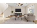 Cozy living room with neutral tones, staircase, ample natural light, and wood flooring at 14827 Longhorn Dr, Mead, CO 80542