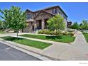 Beautiful two-story home with lush landscaping and a welcoming covered porch, perfect for relaxing outdoors at 15958 Humboldt Peak Dr, Broomfield, CO 80023