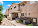 Well-maintained townhome exterior featuring a cozy patio, lush landscaping, and inviting curb appeal, perfect for comfortable living at 1601 Great Western Dr # M2, Longmont, CO 80501